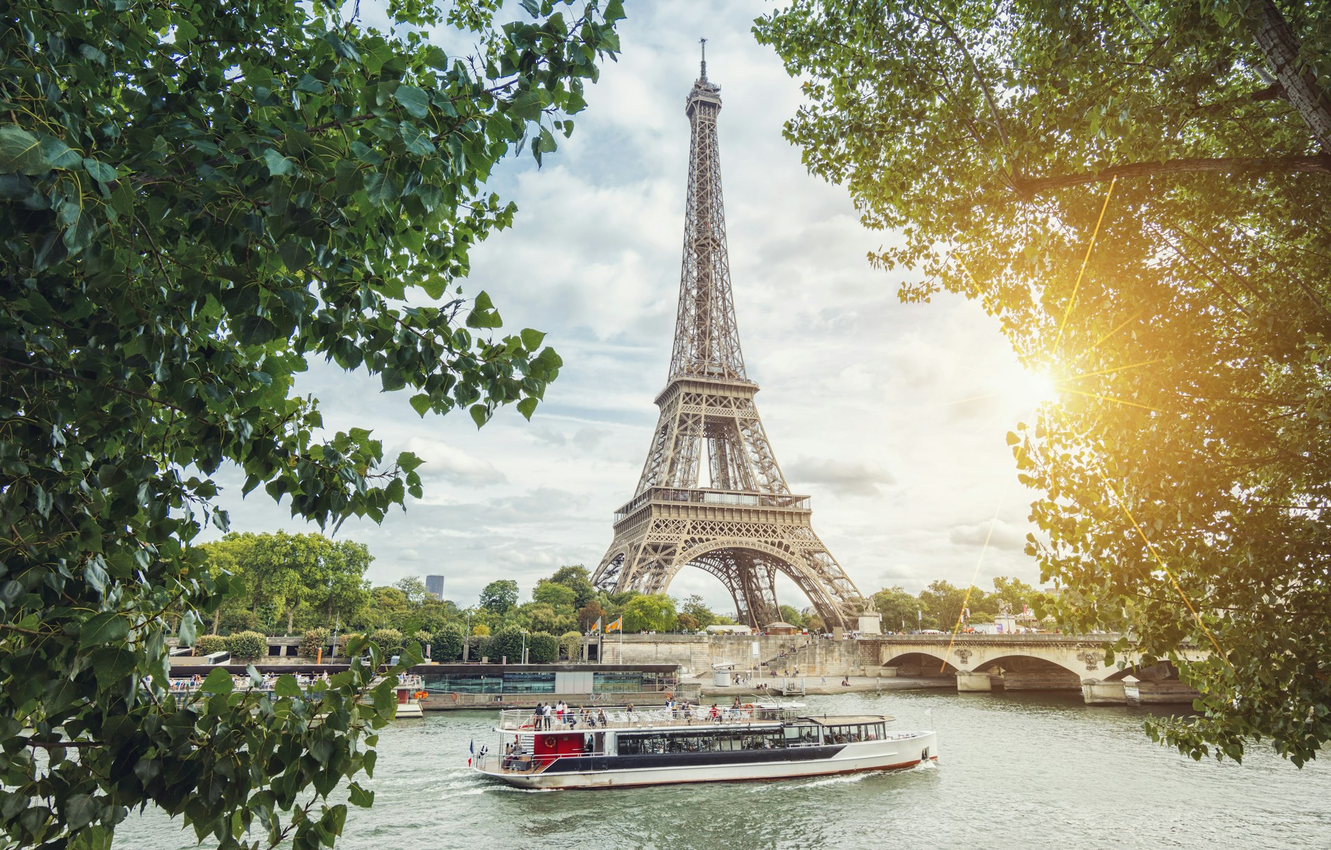 A river boat passes in front of the Eiffel Tower. 