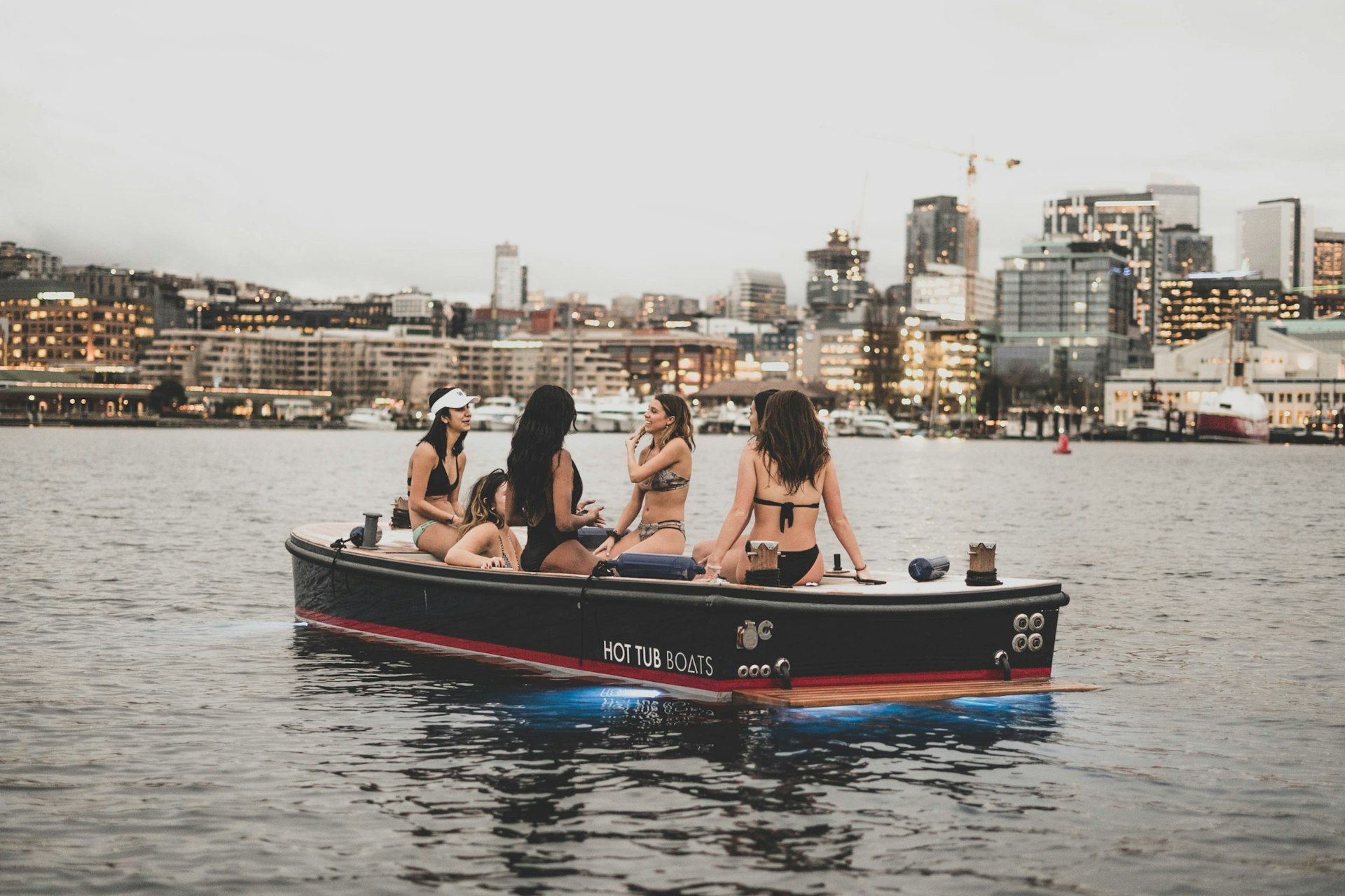 Four girls sitting on the edge of a hot tub boat