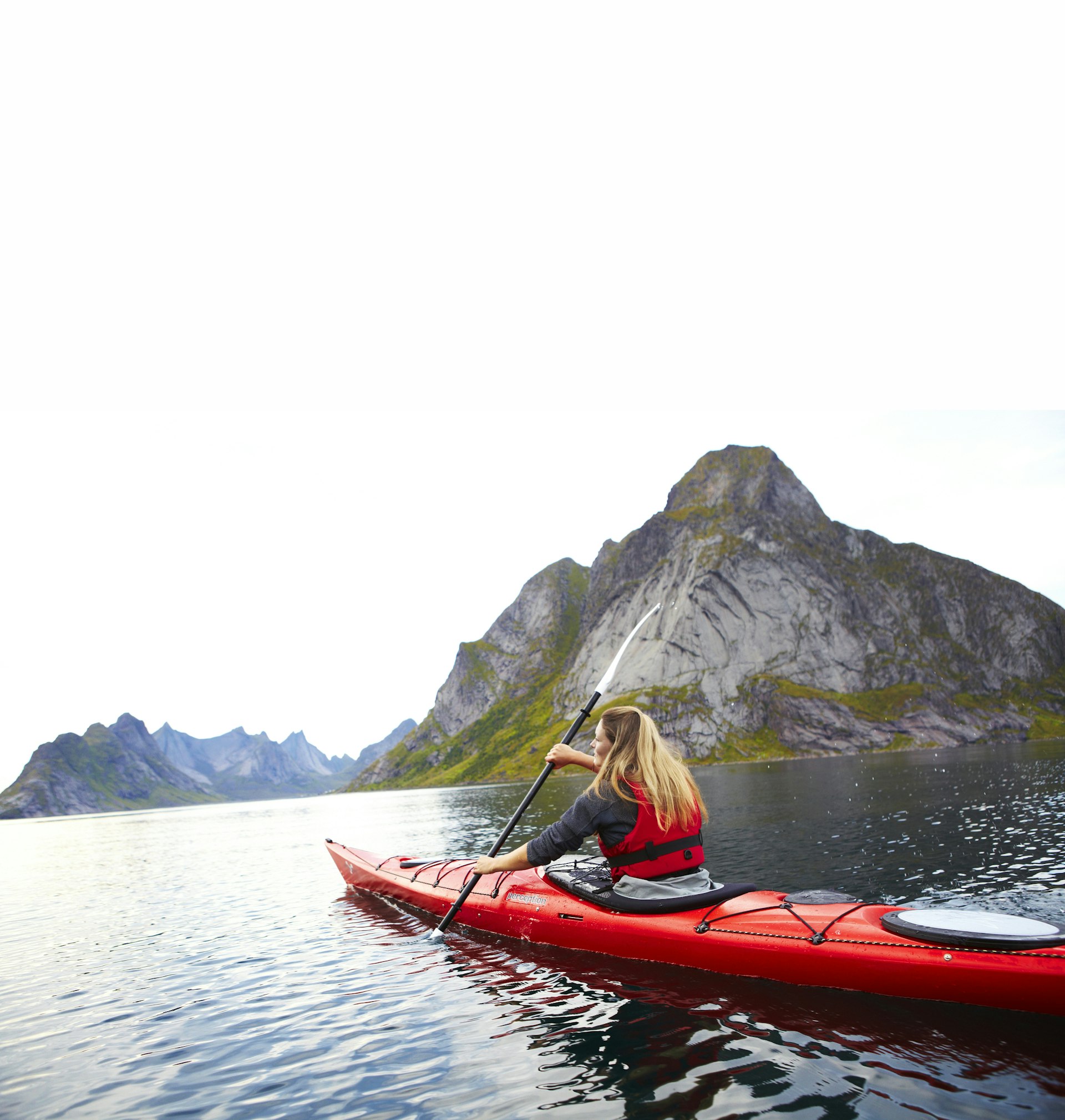 A woman kayaking through a fjord