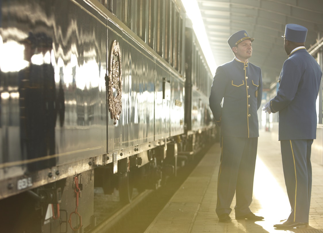Station attendants beside Orient-Express at station.