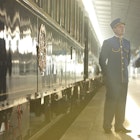 Station attendants beside Orient-Express at station.