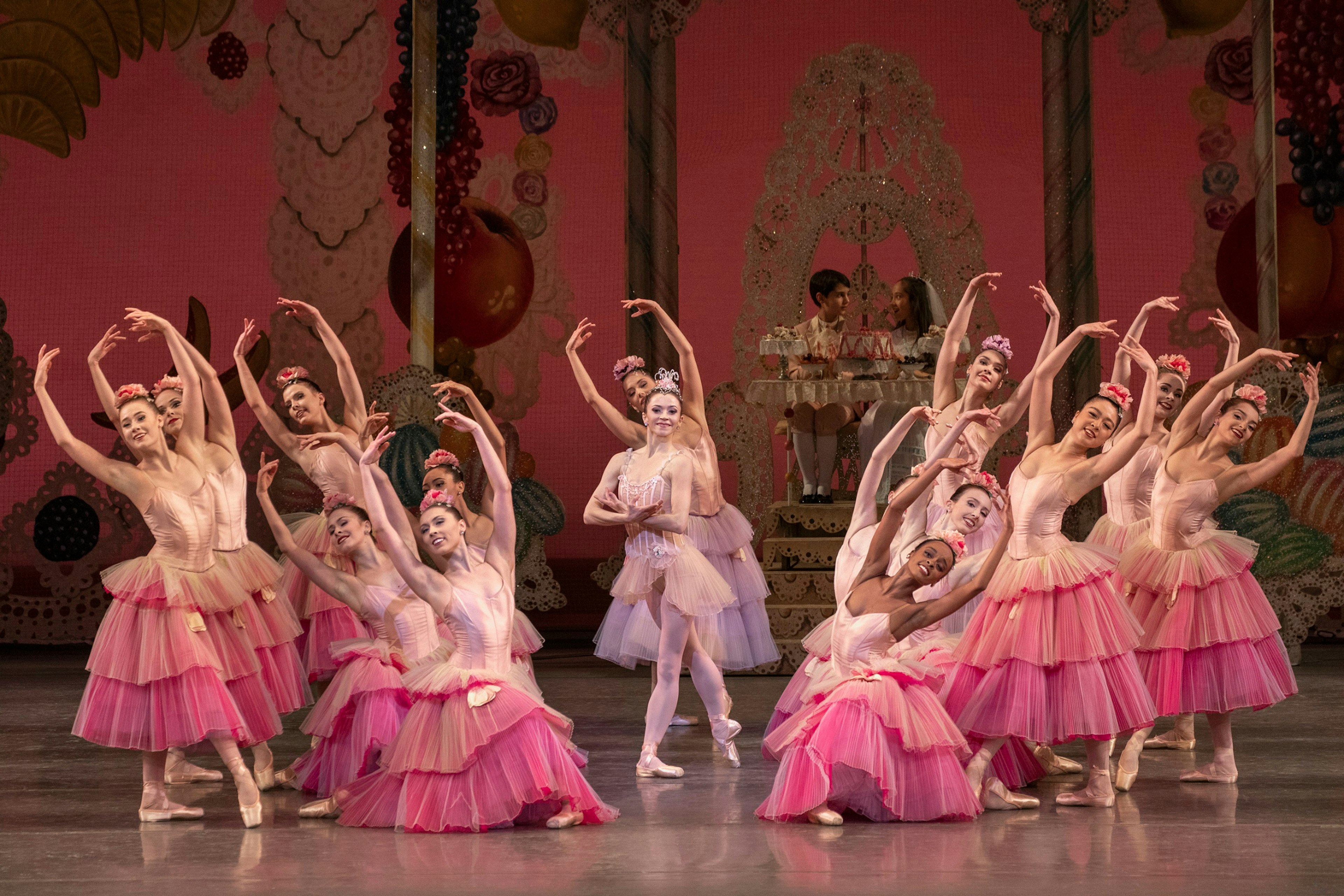 A group of female dancers on stage, dressed in pink