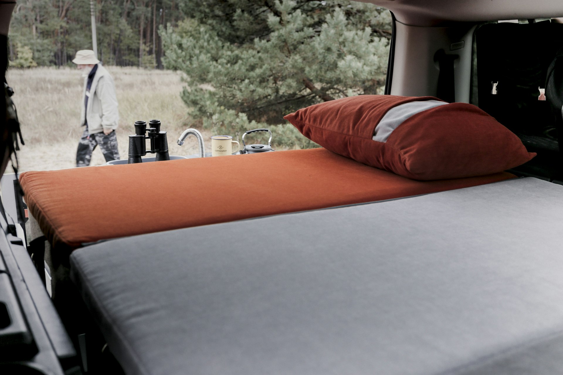 A foldable mattress on display in the trunk of an SUV