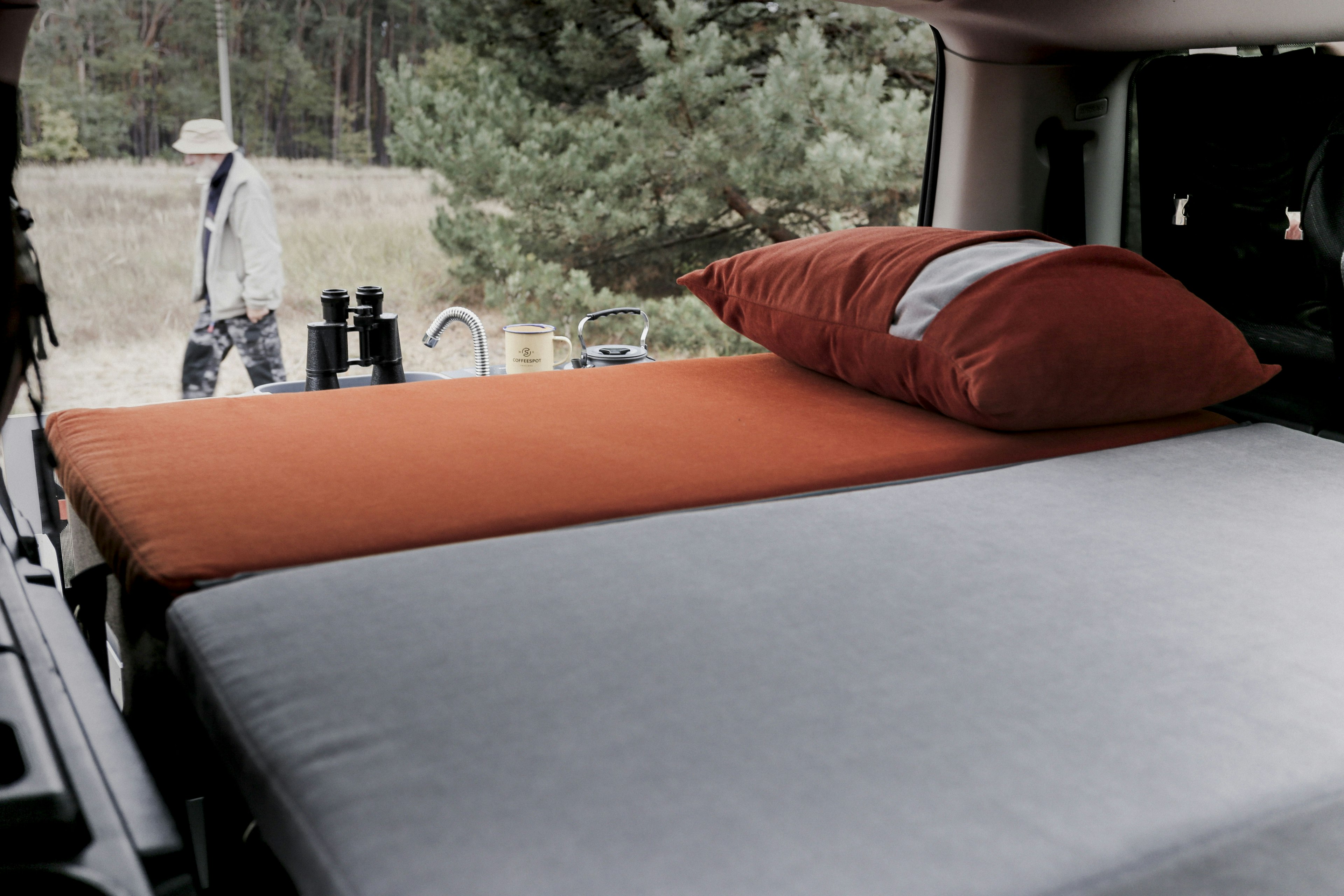 A foldable mattress on display in the trunk of an SUV