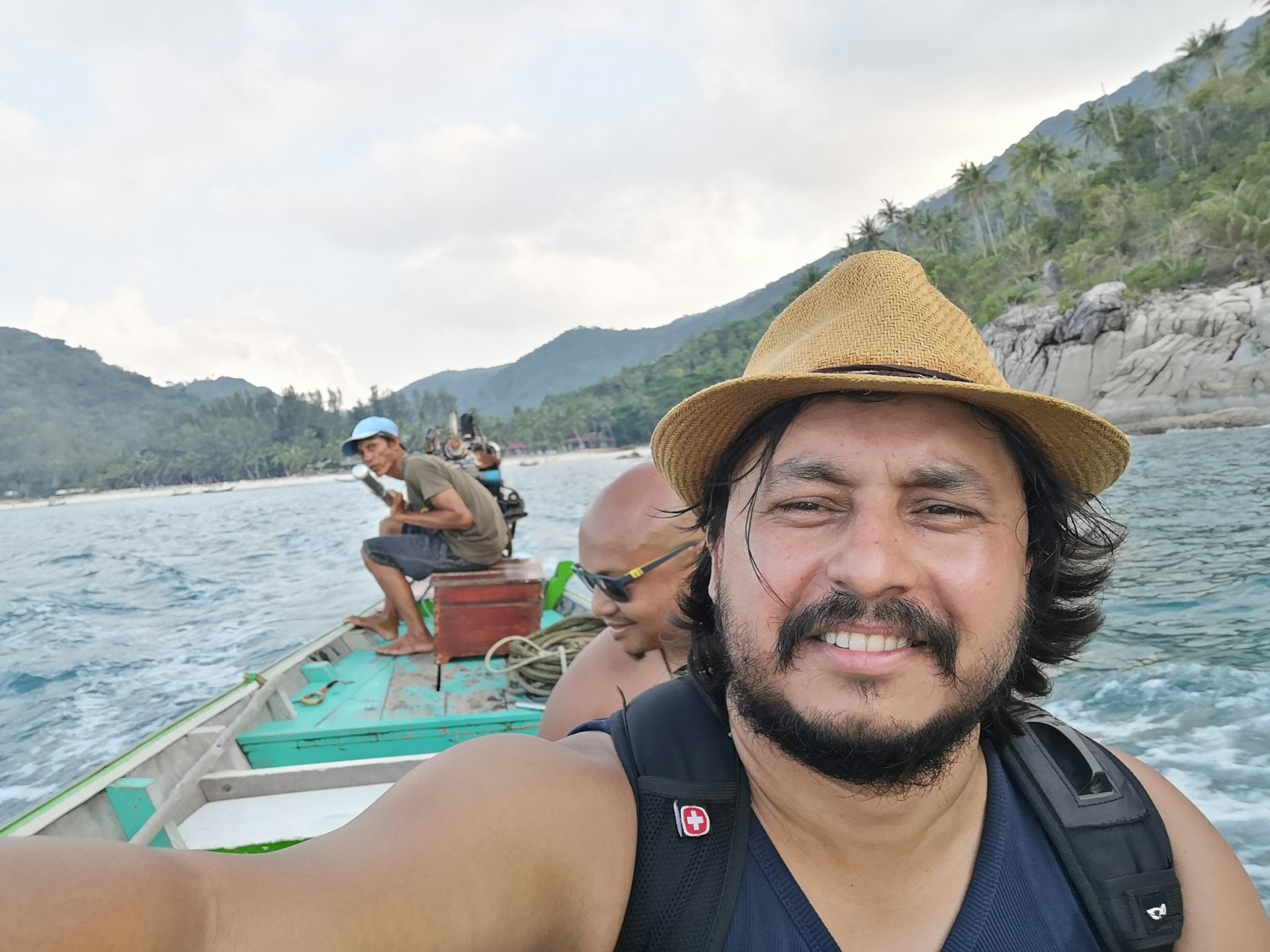 A man posing for a selfie in a ride in a long-tail boat