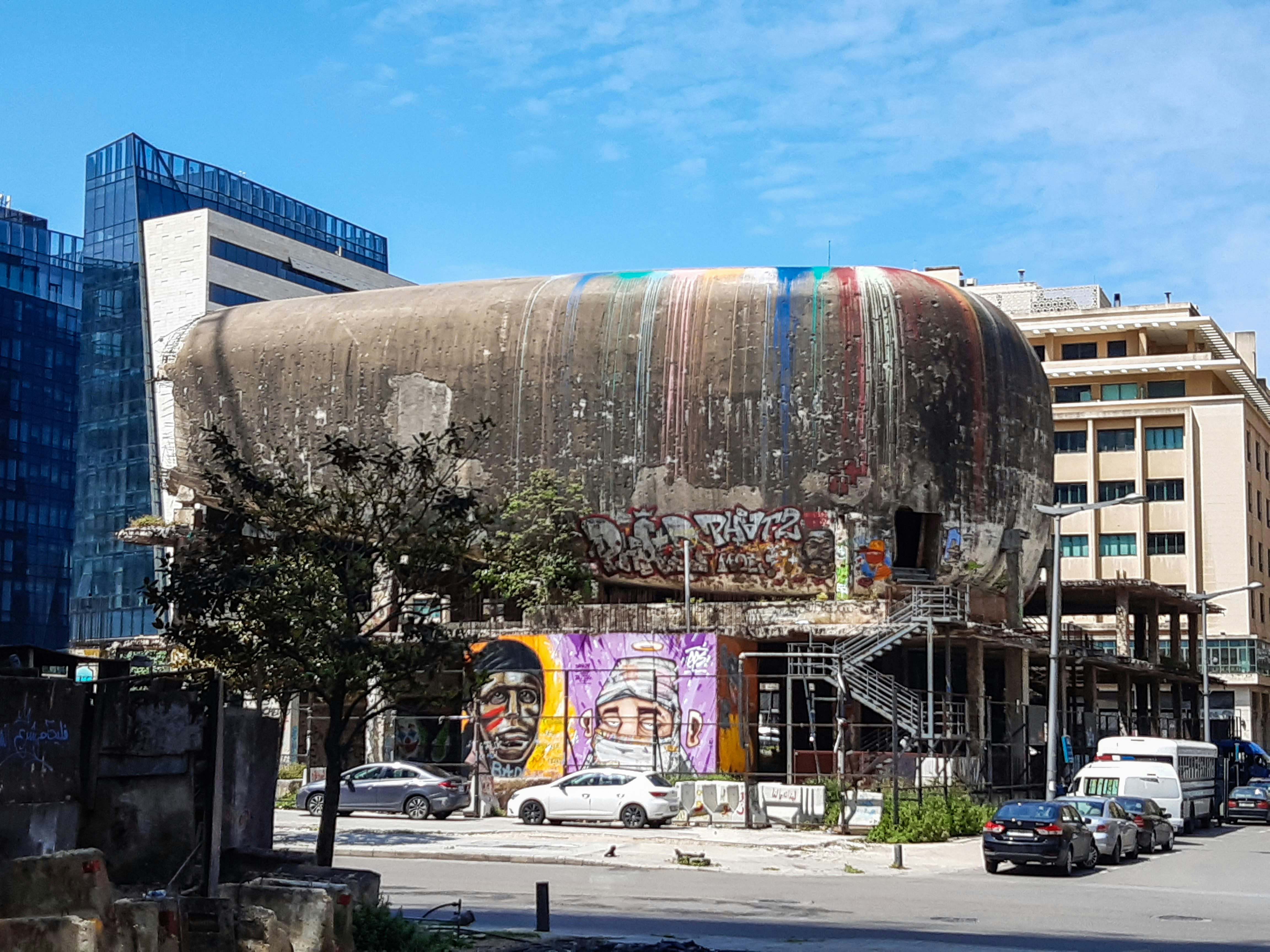 An egg-shaped building painted with graffiti 