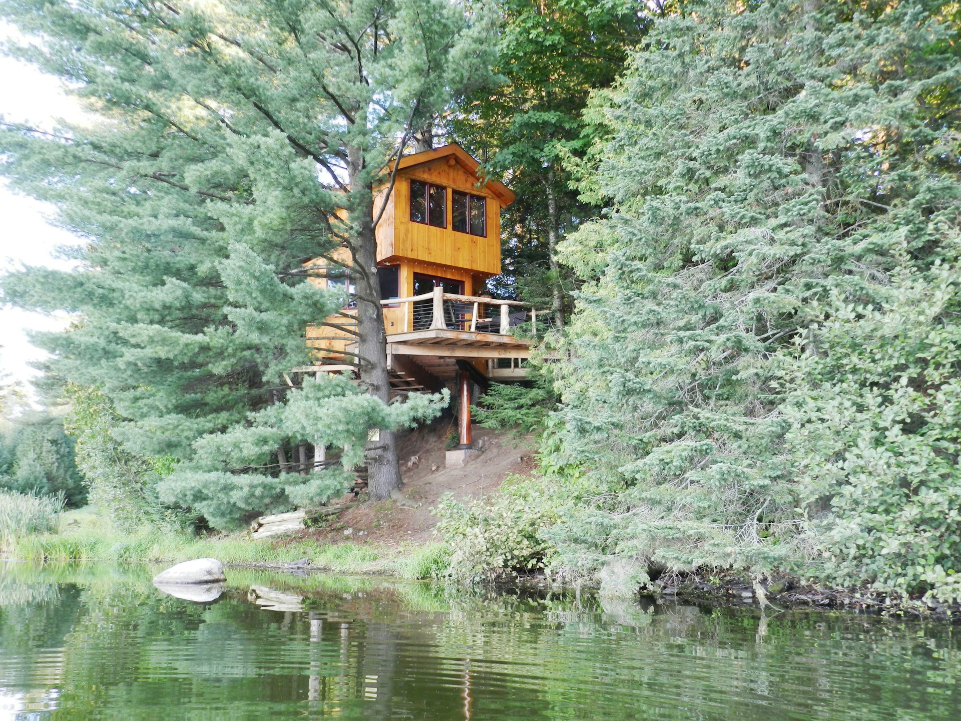 A treehouse cabin in the middle of the woods, overlooking a river in Vermont