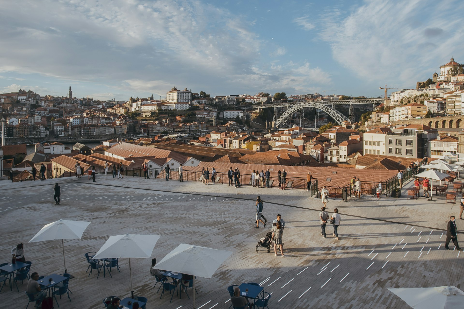Diners sit at open-air tables on a rooftop overlooking Porto