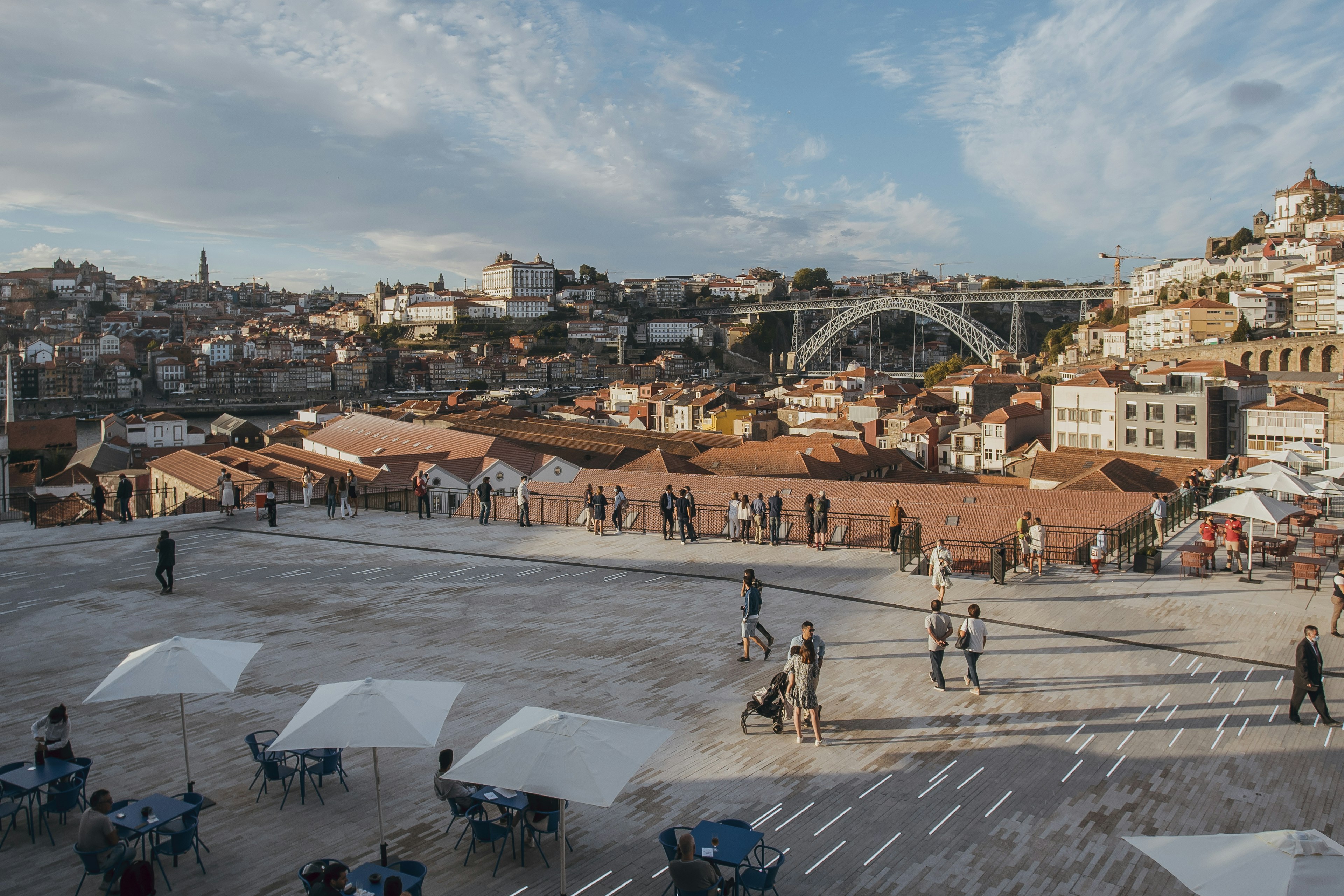 Diners sit at open-air tables on a rooftop overlooking Porto