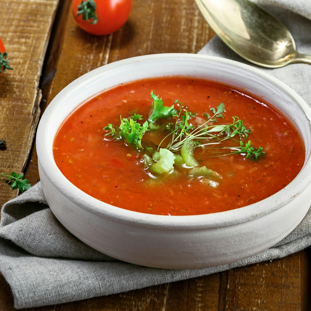 A bowl of traditional Spanish gazpacho on a rustic table.