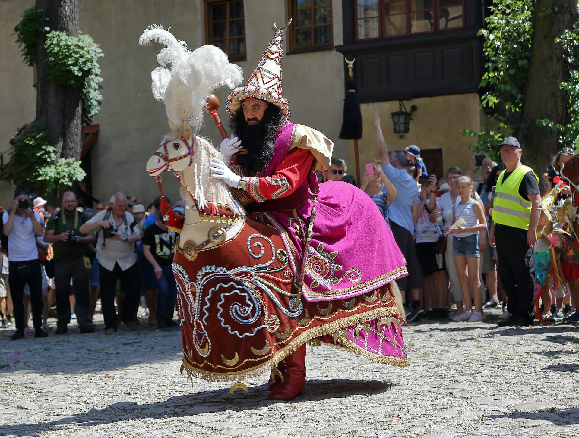 A man in a purple costume and feathered headdress at the traditional Lajkonik Festival in Kraków, Malopolskie, Poland