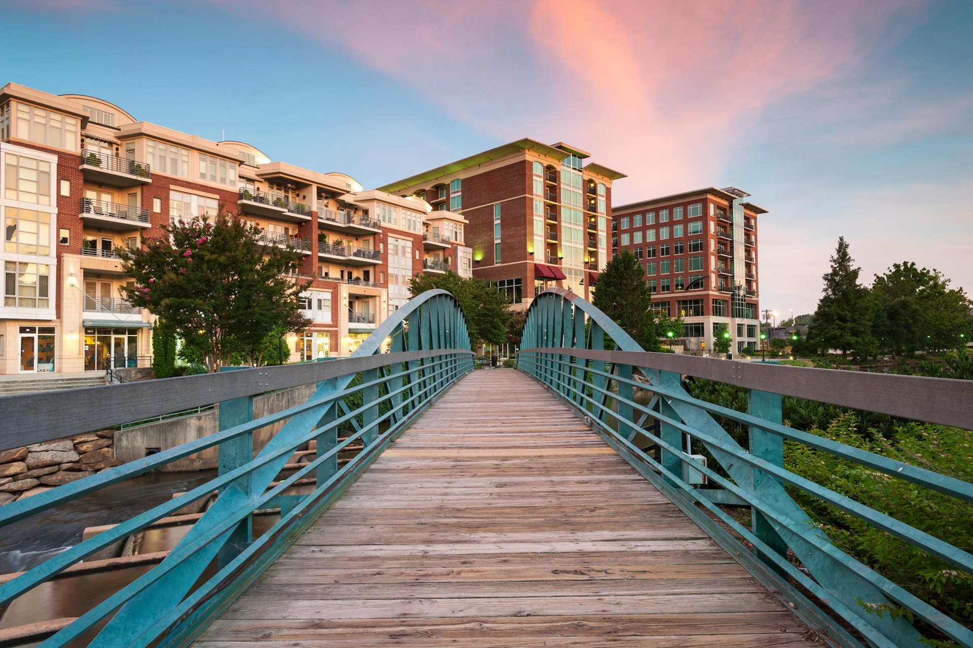 A boardwalk near condominiums under a sky at dusk