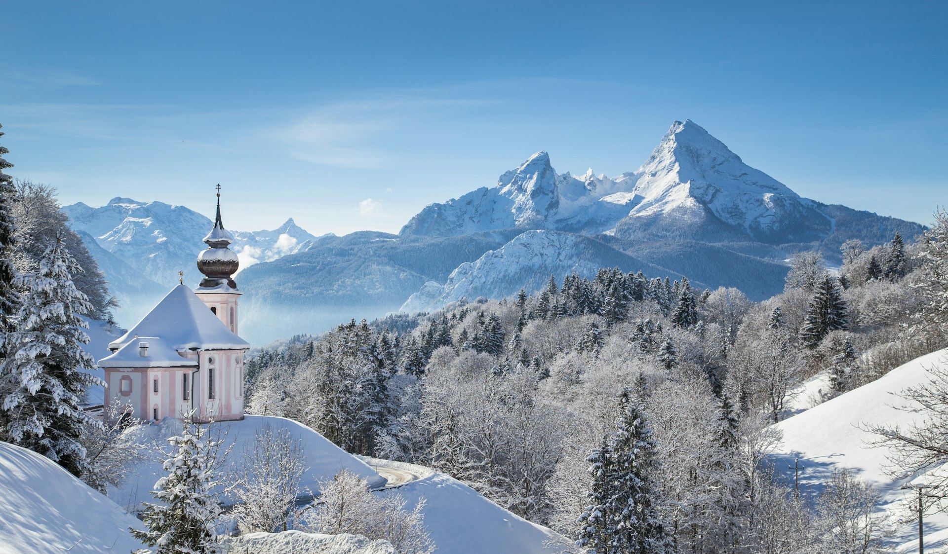 Panoramic view of beautiful winter landscape with a church in the foreground and a mountain in the background.