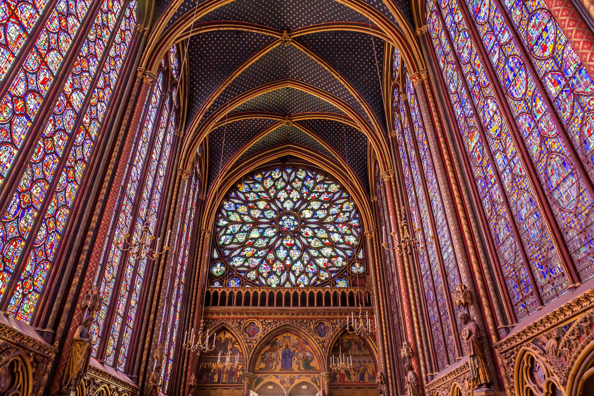 The colorful stained glass windows inside of a gothic French church. 