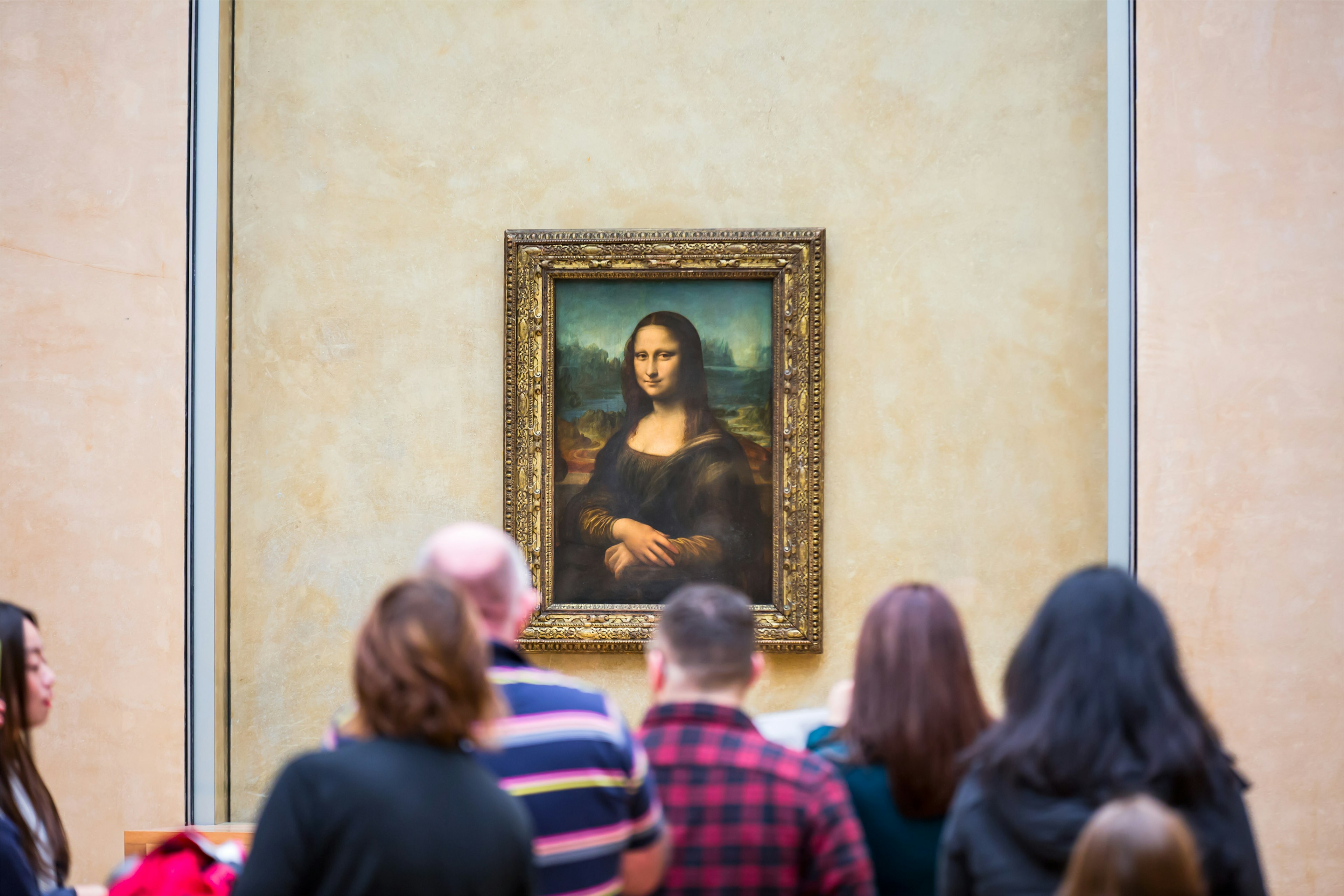 A crowd of visitors in front of Leonardo DaVinci's Mona Lisa at the Louvre Museum.