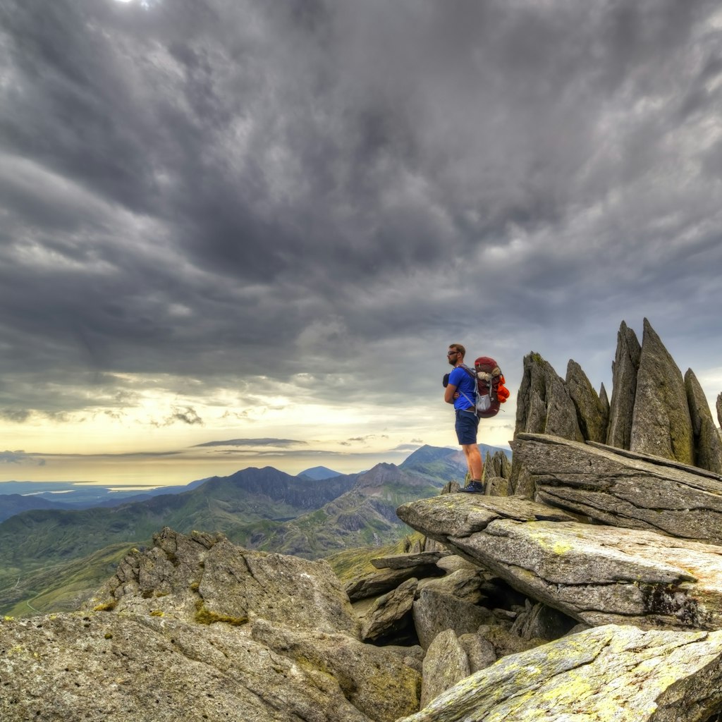 An explorer explores the Gylder Fach high up on Snowdonia moutain range in Wales. Emphasising exploration and traveling, backpacking and hiking in the outdoor world.