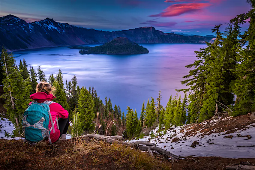 Backpacker Girl Looking at Crater Lake at Sunset Wizar Island and Watchman Peak in the Background