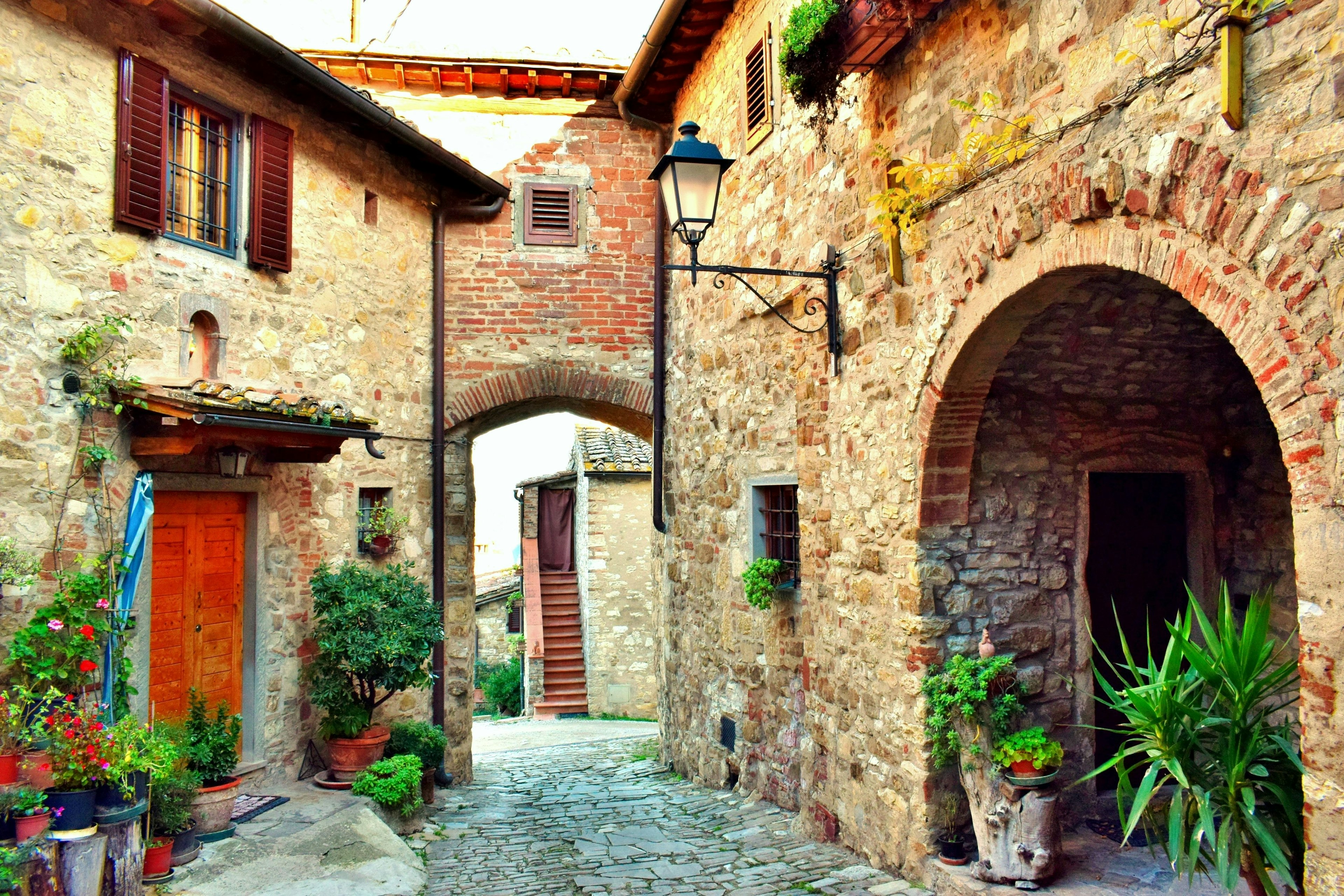 Two medieval stone buildings linked by a brick archway