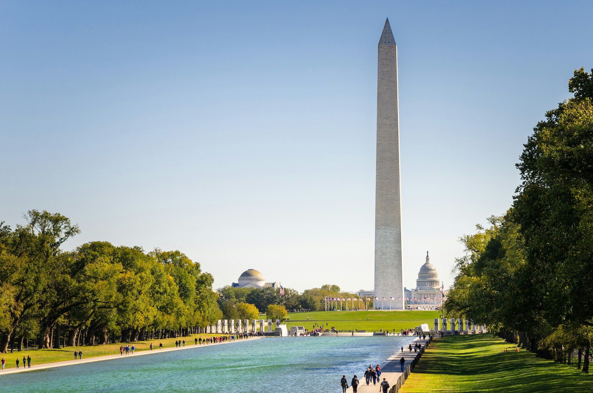 A tall monument stands in the distance on a bright day. 