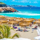 Umbrellas and beach chairs on El Duque beach at Costa Adeje. 