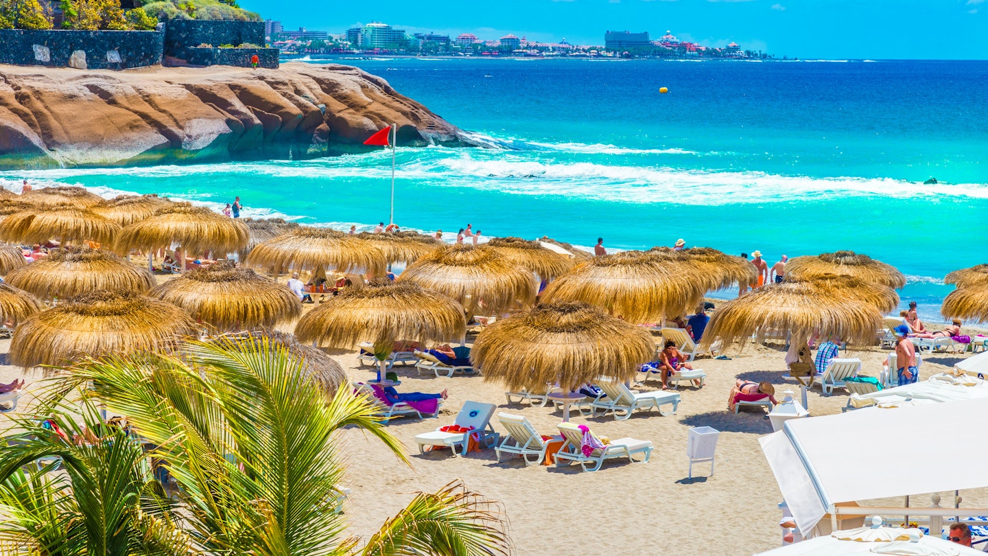 Umbrellas and beach chairs on El Duque beach at Costa Adeje. 