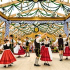 September 21, 2017: Couples dancing in traditional costumes inside a beer tent during Oktoberfest.