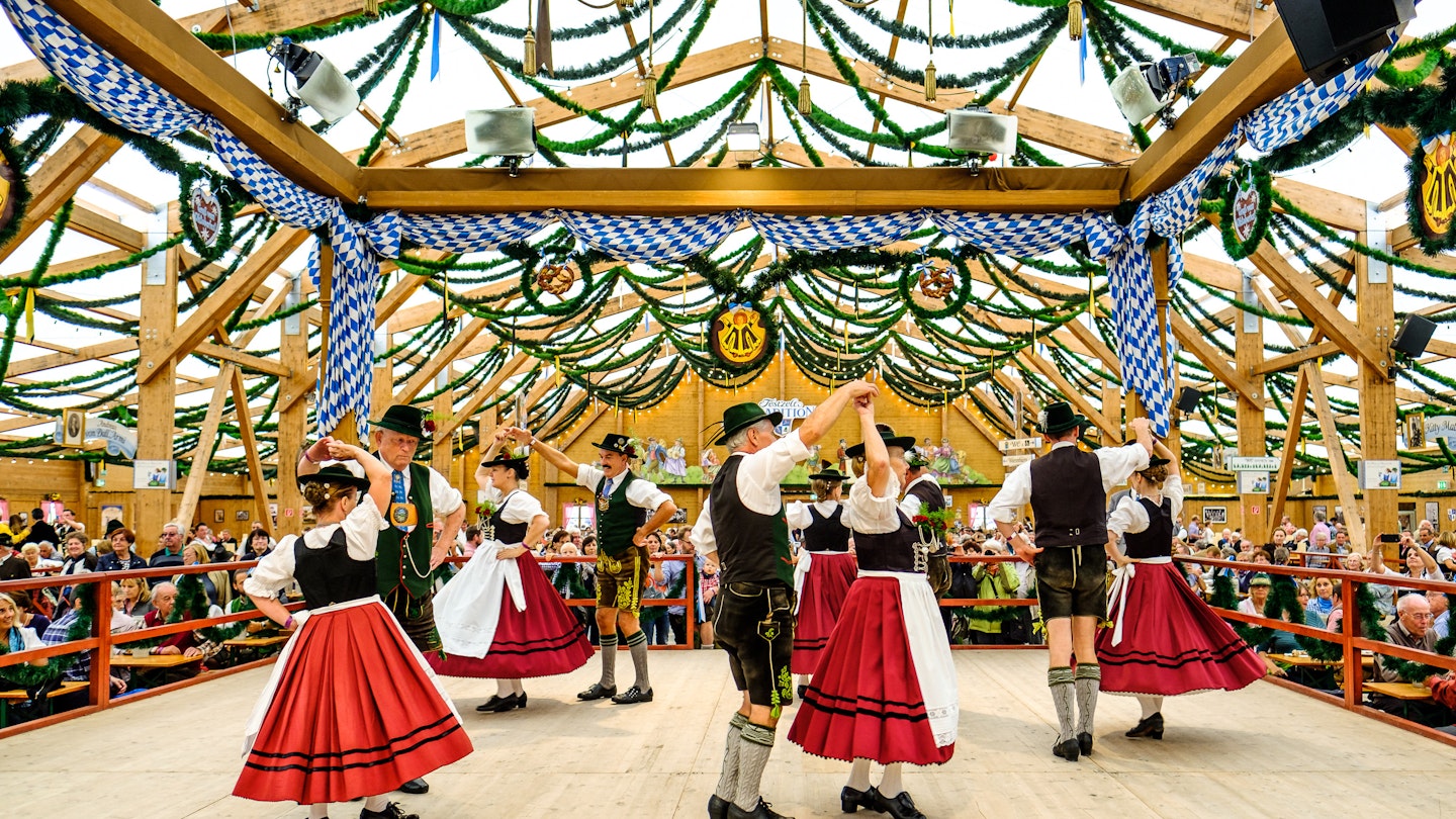 September 21, 2017: Couples dancing in traditional costumes inside a beer tent during Oktoberfest.