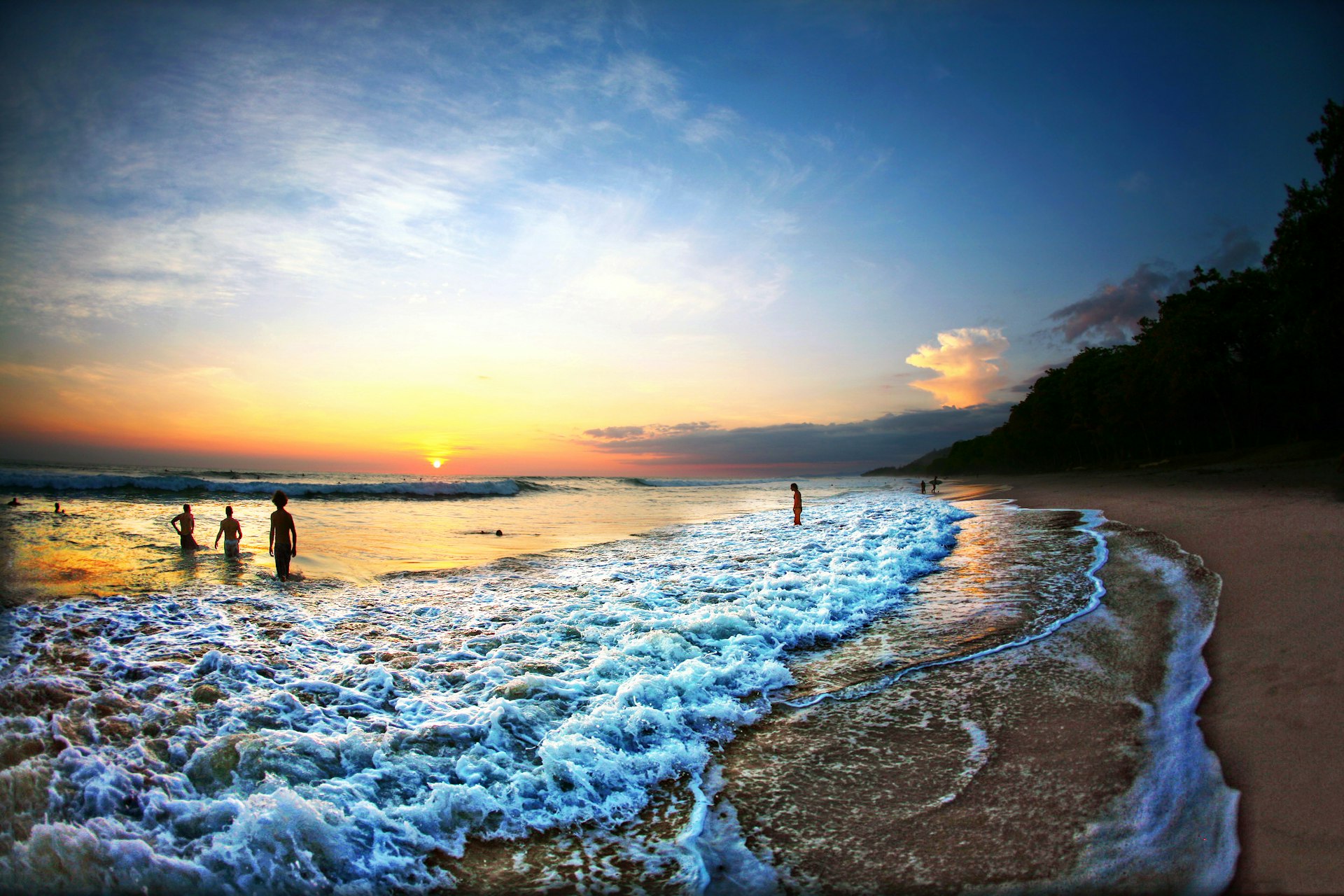 People swimming in ocean at sunset in Costa Rica