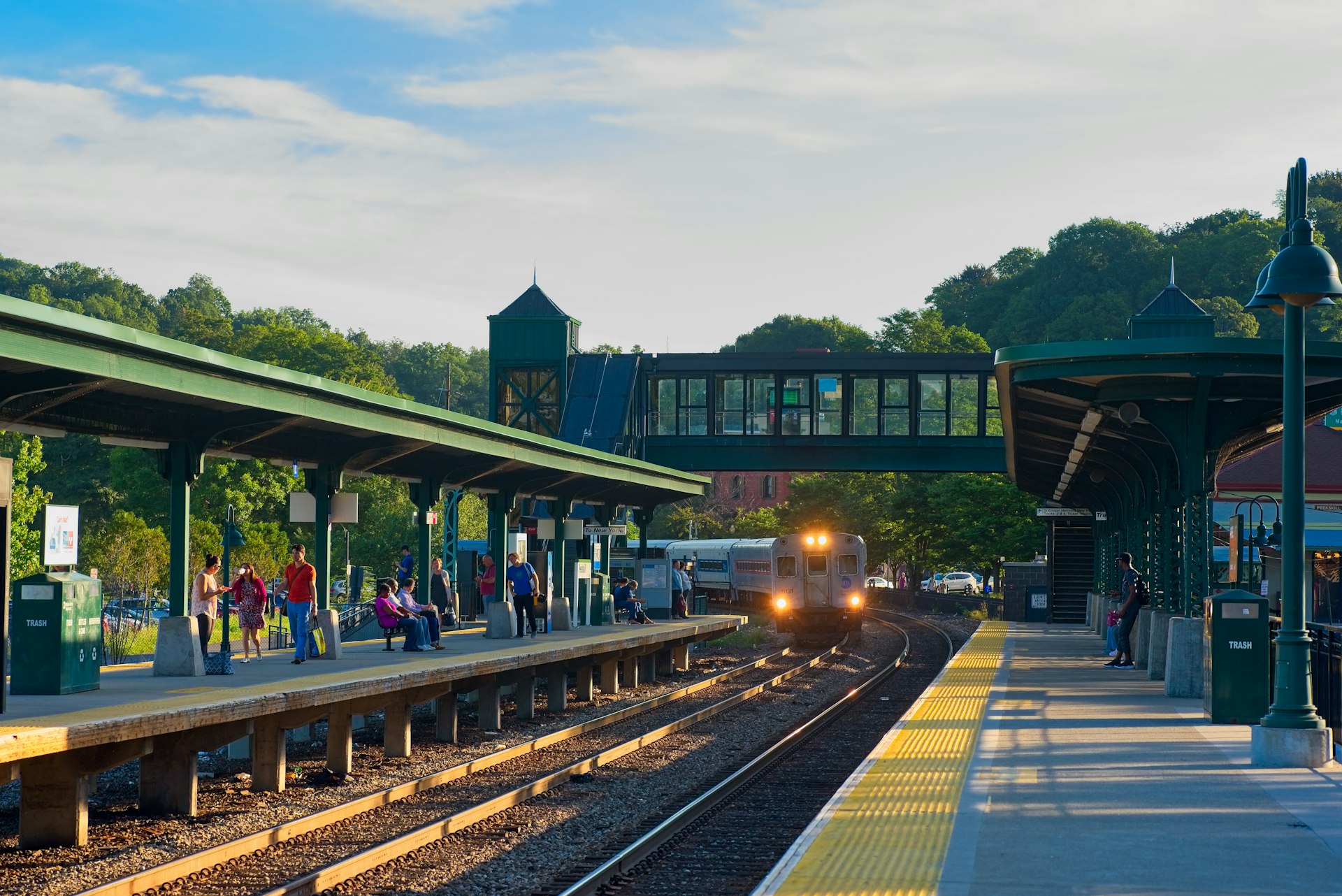 A train coming into a station in an idyllic leafy setting