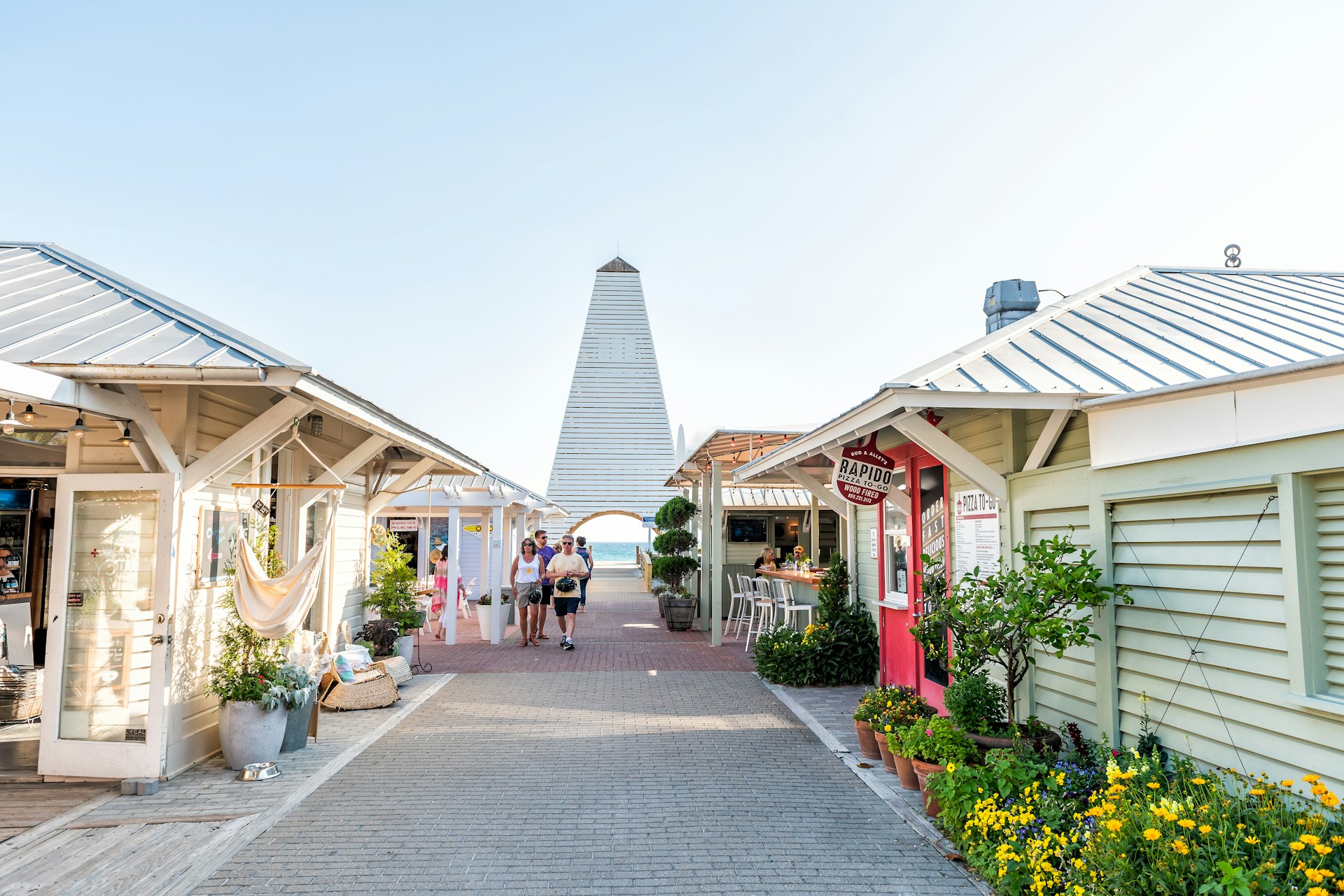 People walk through a a quaint seaside shopping mall 