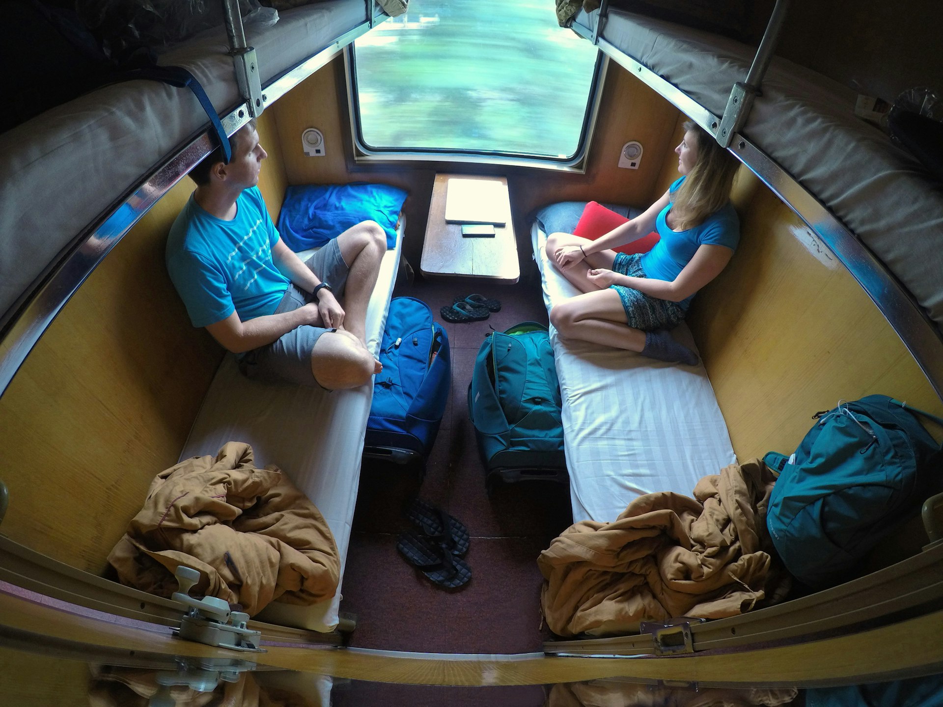 Young traveler couple looking through the window while riding on a sleeper train