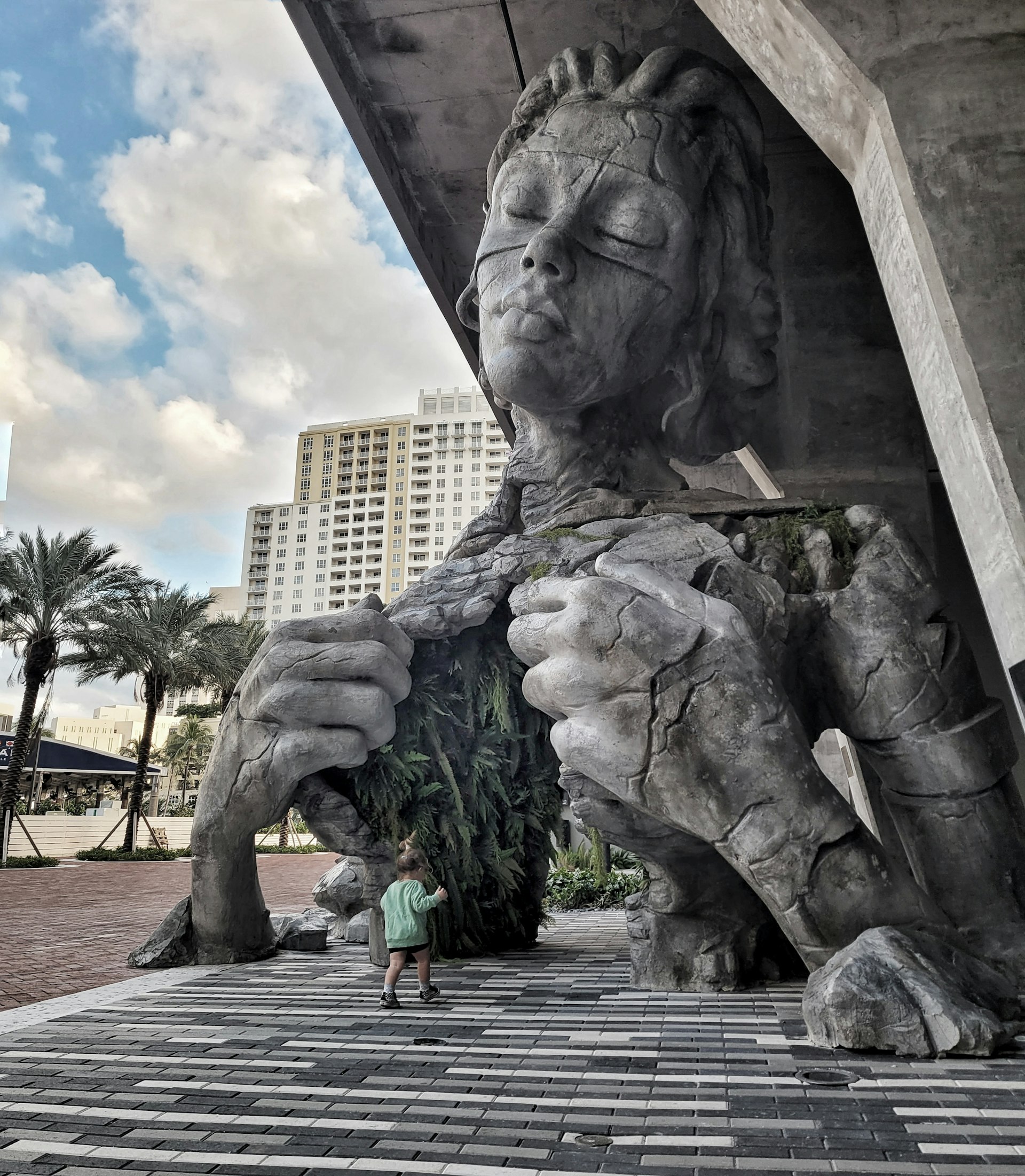 A picture of the sculpture with a little child heading towards the fern tunnel