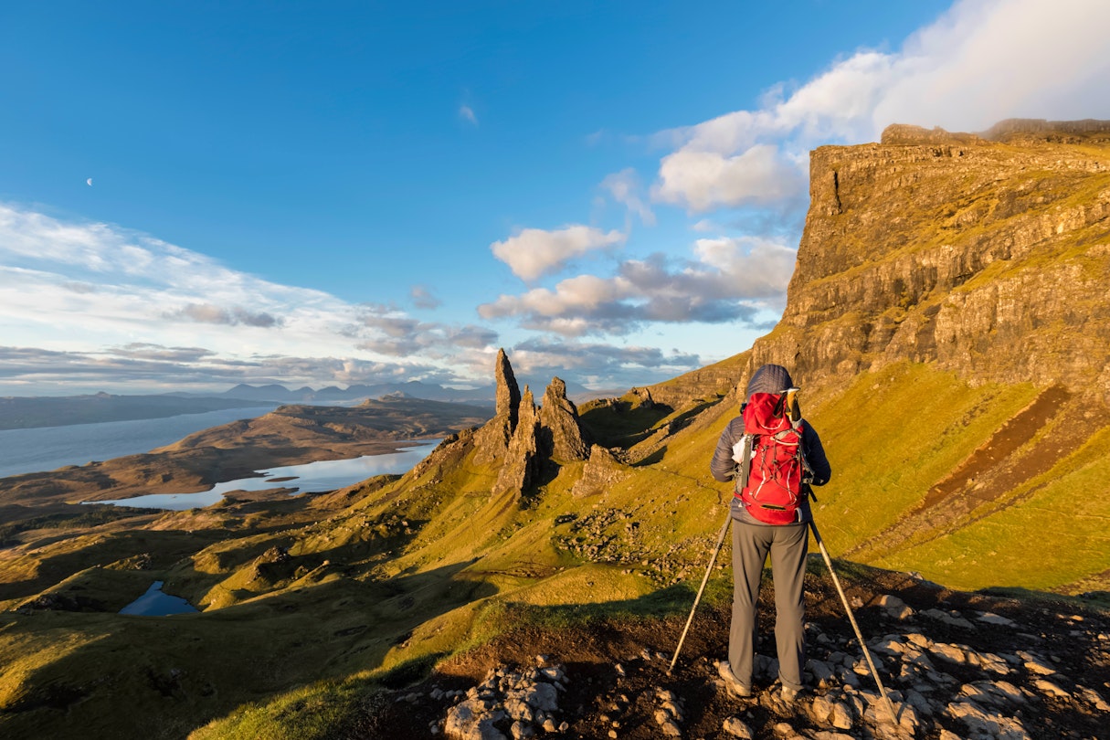 A hiker taking pictures near The Storr mountain peak on the Isle of Skye.