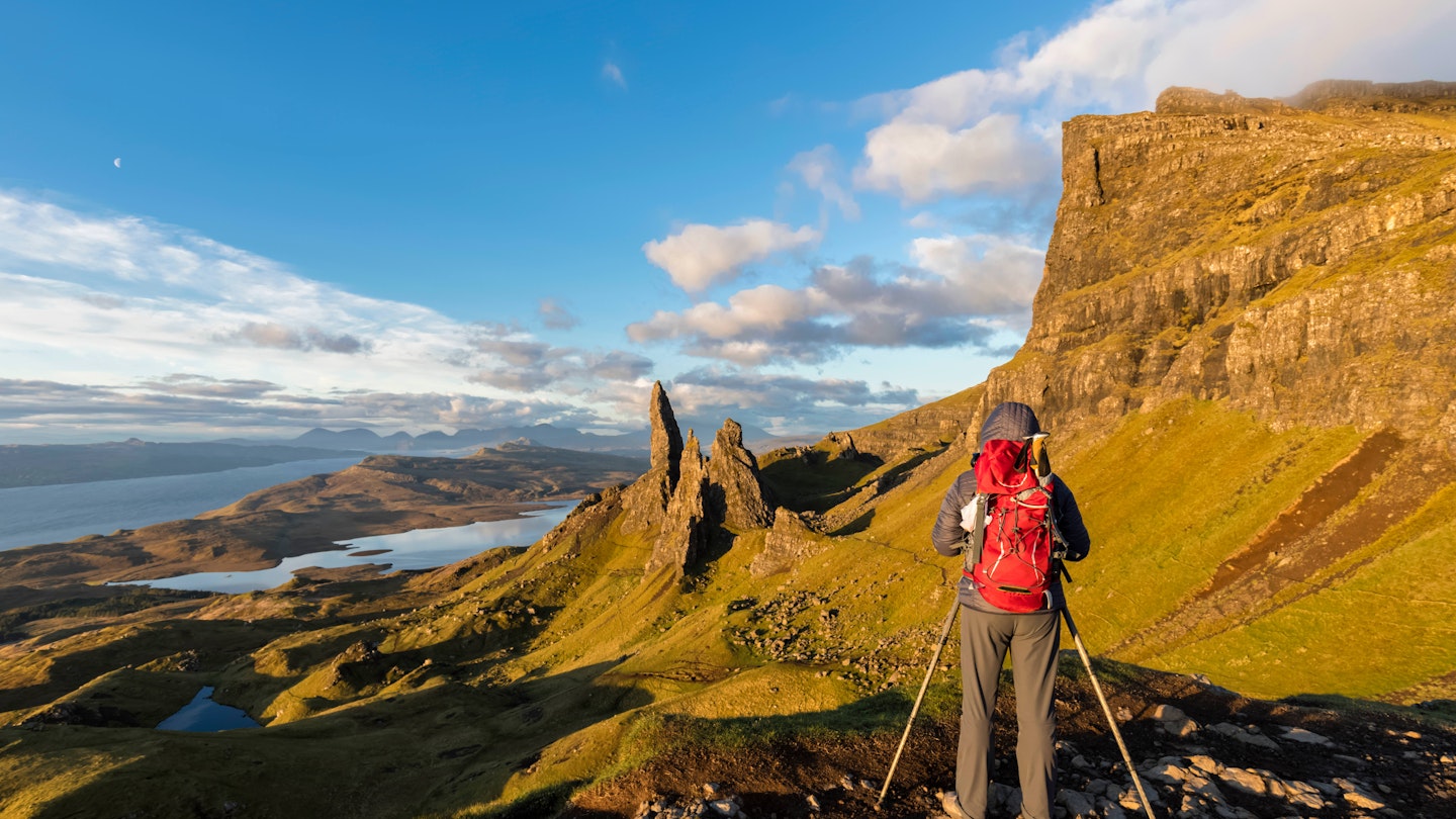 A hiker taking pictures near The Storr mountain peak on the Isle of Skye.