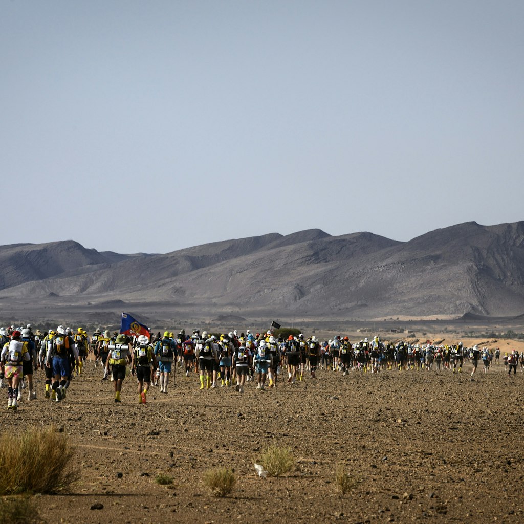 People compete in the fourth stage of the 34th edition of the Marathon des Sables between Jebel El Mraier and Rich Mbirika in the southern Moroccan Sahara desert, on April 10, 2019. - The 34th edition of the marathon is a live stage 250 kilometres race through a formidable landscape in one of the world's most inhospitable climates. (Photo by JEAN-PHILIPPE KSIAZEK / AFP)        (Photo credit should read JEAN-PHILIPPE KSIAZEK/AFP via Getty Images)