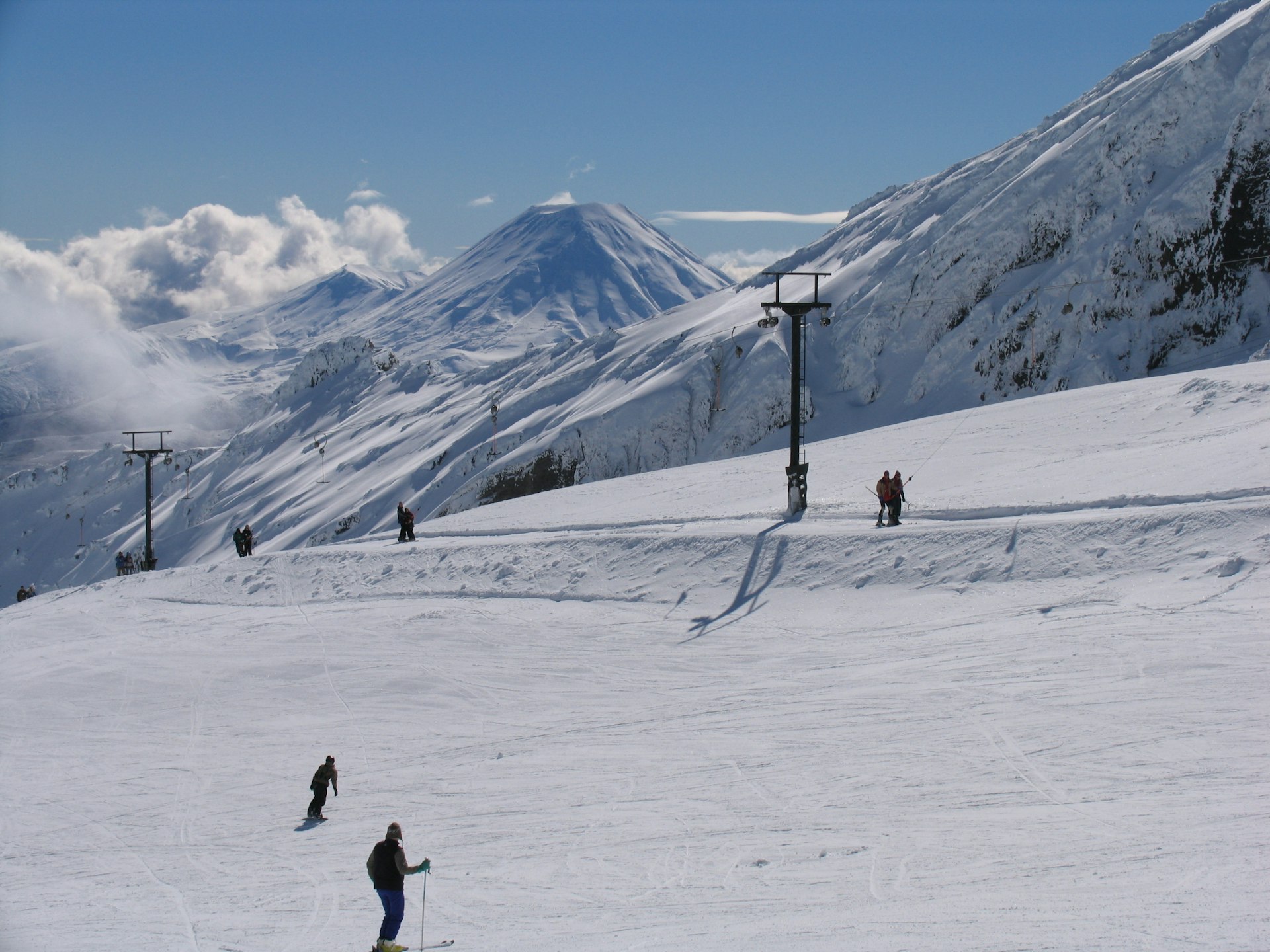 Skiers walk up a steep snowy mountain in Whakapapa 