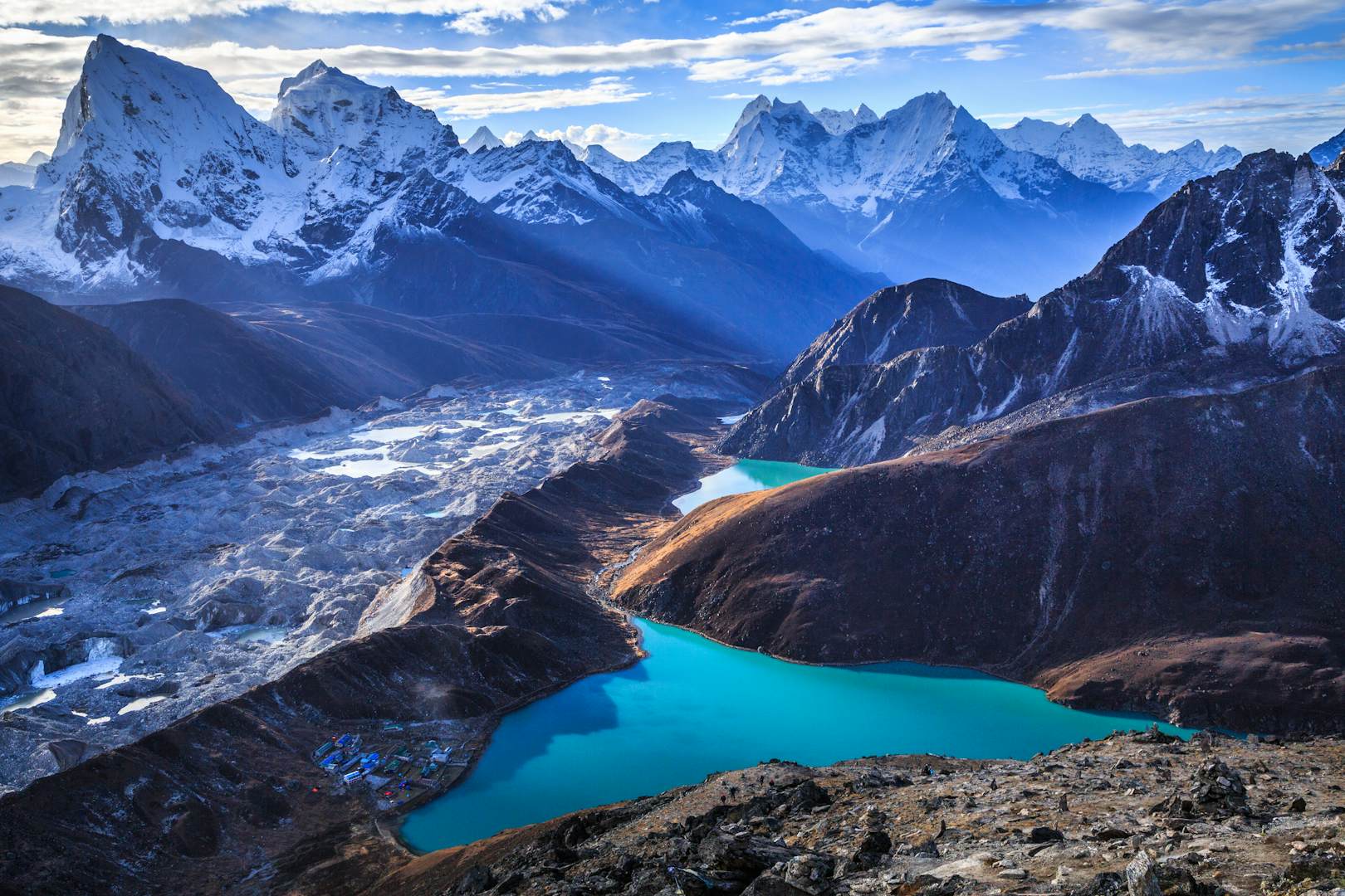 喜马拉雅山脉（左侧的霍拉特和塔巴切），Ngozumpa冰川和Gokyo Lakes（世界上最高的淡水湖泊，印度教徒和佛教徒的神圣）的壮丽景色，如Gokyo Ri（5,357 m）所见，位于亚洲尼泊尔东部Solukhumbu地区Khumbu地区的萨加马莎国家公园的Gokyo村。