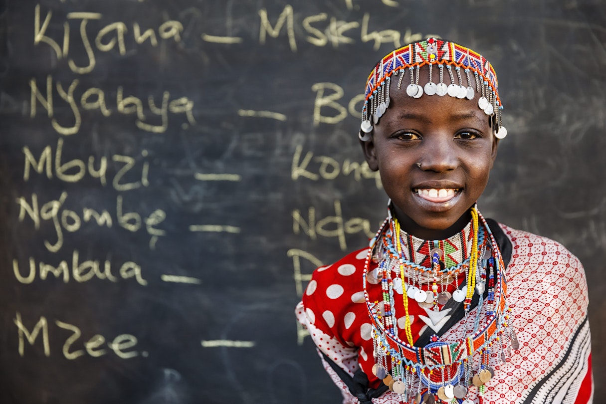 A smiling child from the Maasai tribe during a Swahili language class in a remote village.