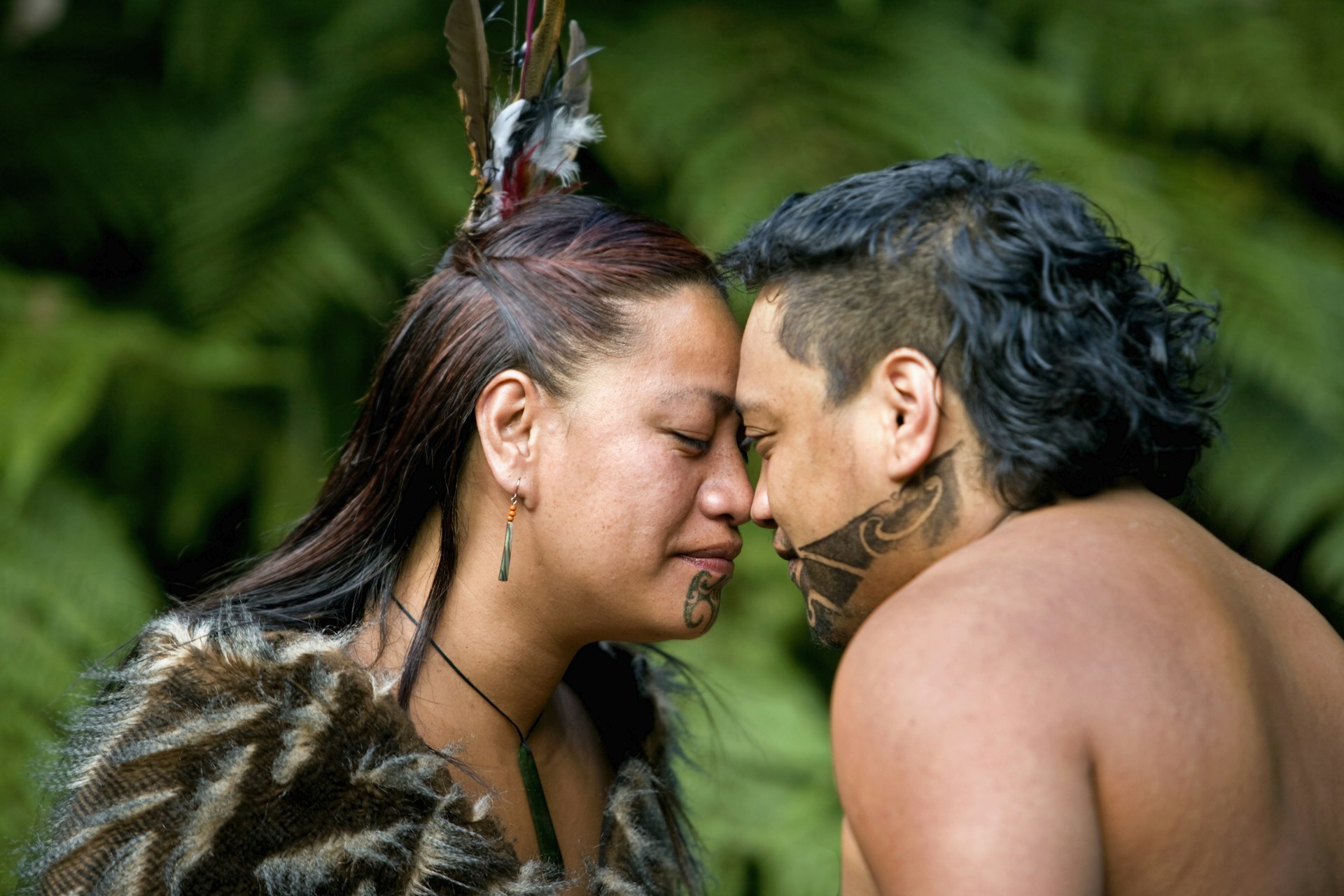 A couple touch heads during a Maori hongi greeting in New Zealand