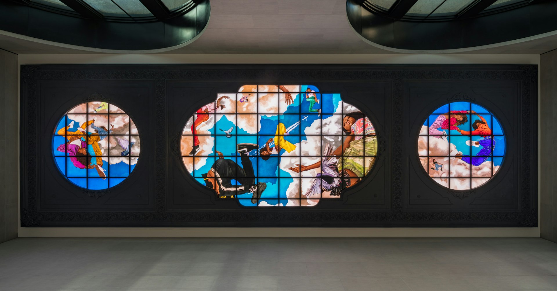 A backlit, hand-painted, stained-glass triptych on the ceiling of Moynihan Train Hall