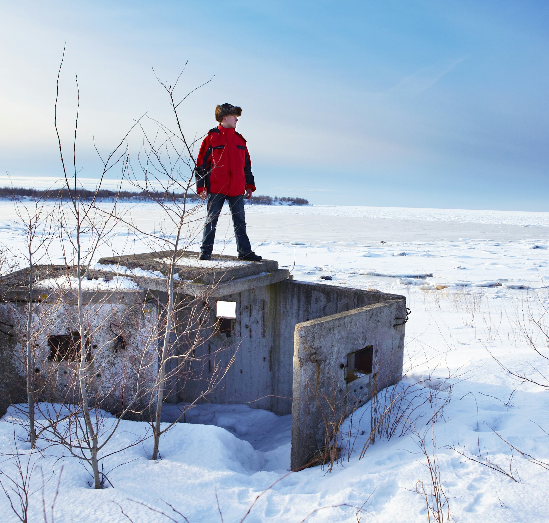 Man standing on Soviet bunker in a snowy landscape