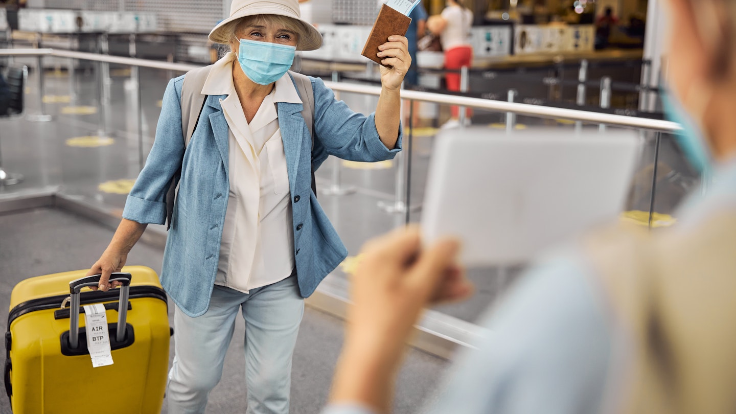 Newly arrived female passenger in a face mask walking towards a man with a sign