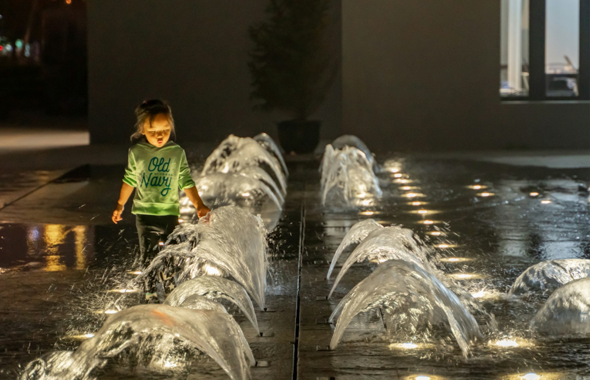 A child playing at a fountain in Xuhui Runway Park