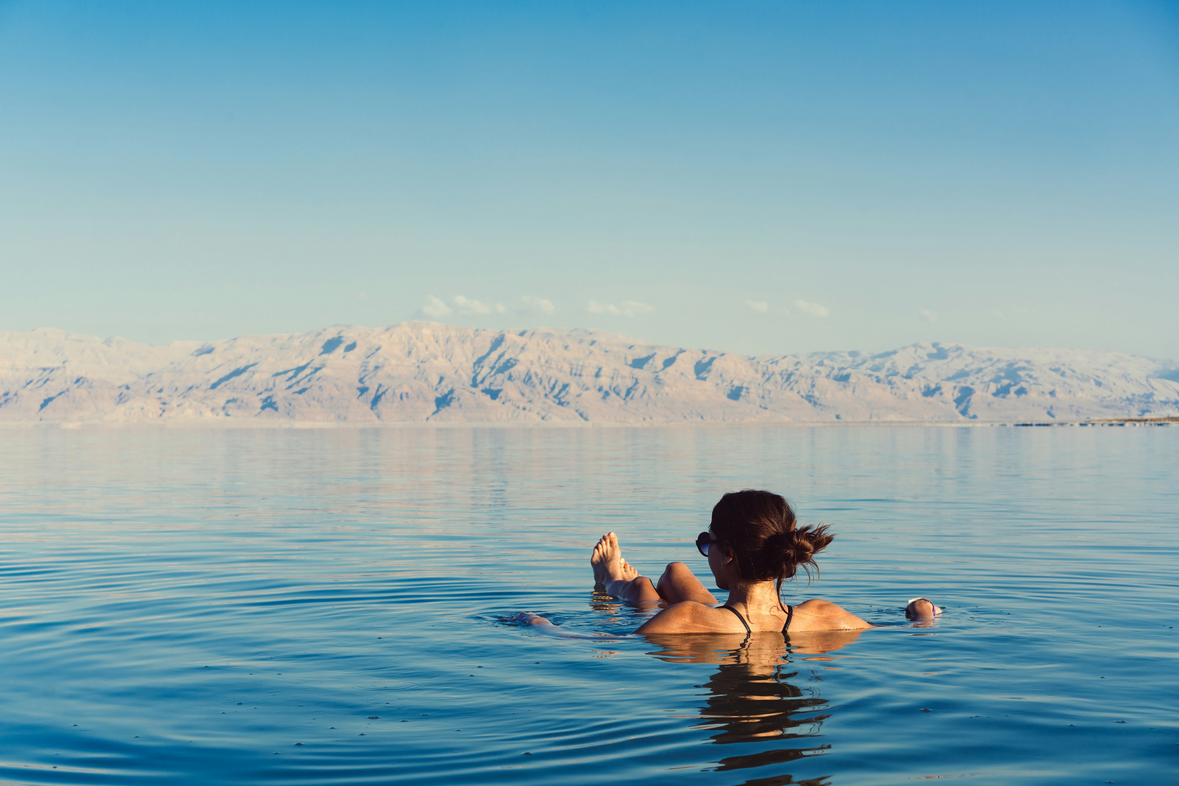 Girl relaxing and swimming in the water of the Dead Sea in Israel