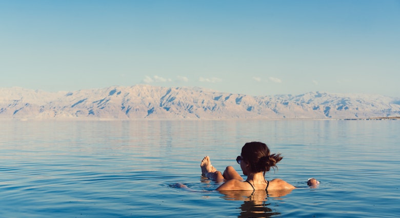 Girl relaxing and swimming in the water of the Dead Sea in Israel