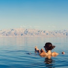 Girl relaxing and swimming in the water of the Dead Sea in Israel
