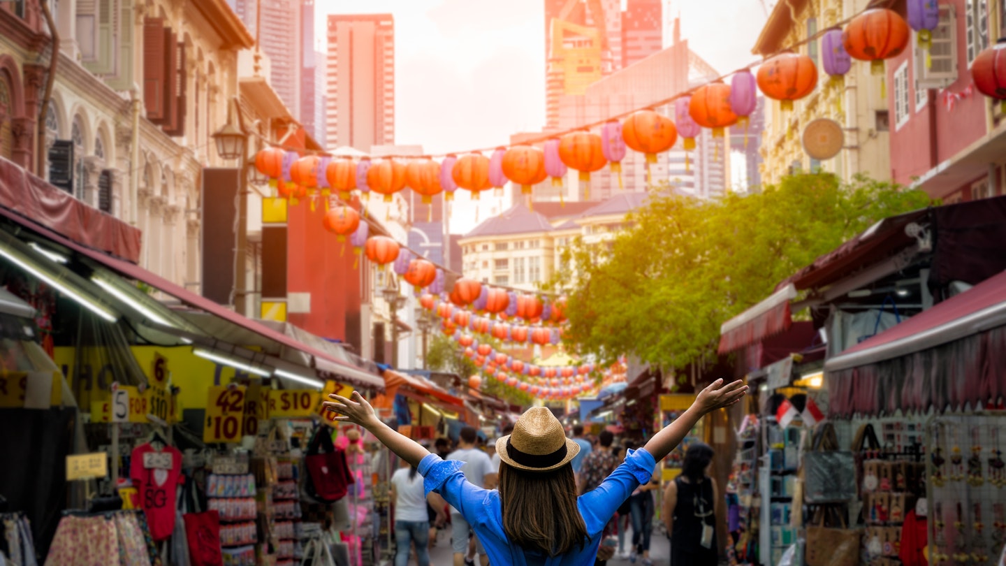 Young woman with a backpack and hat at Chinatown in downtown Singapore.