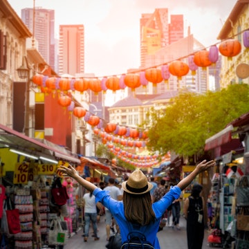 Young woman with a backpack and hat at Chinatown in downtown Singapore.