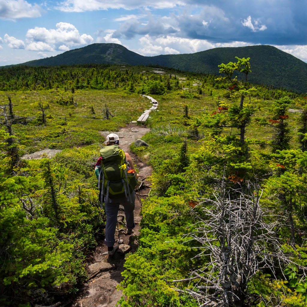 Hiker on the Appalachian Trail in Maine with Lush Mountain.