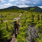 Hiker on the Appalachian Trail in Maine with Lush Mountain.